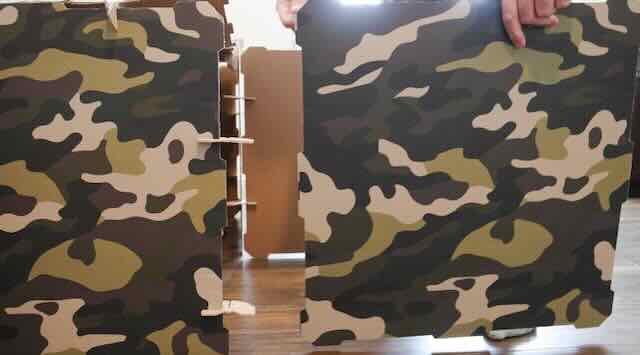 Two camouflage printed kids play fort kit wall panels being assembled together.