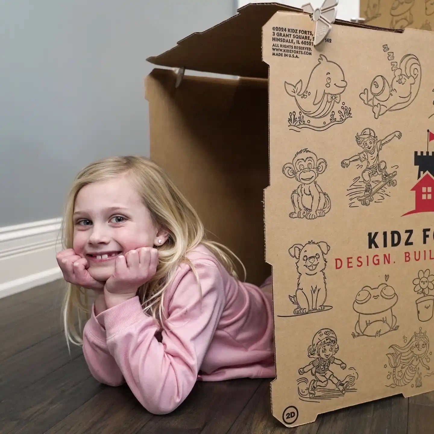 Kidz Forts cardboard play fort kit with a smiling girl inside, featuring fun animal and character illustrations.