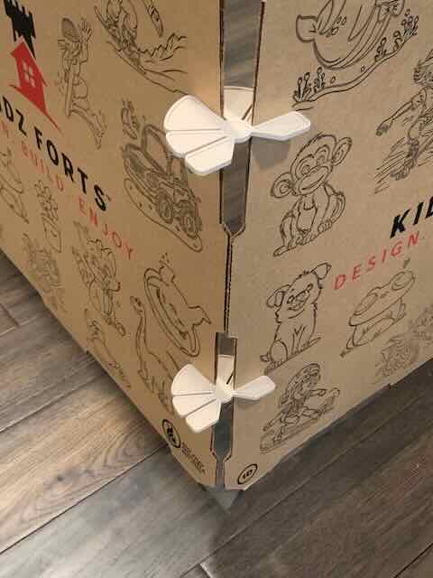 Cardboard fort kit with corner support structure on a wooden floor